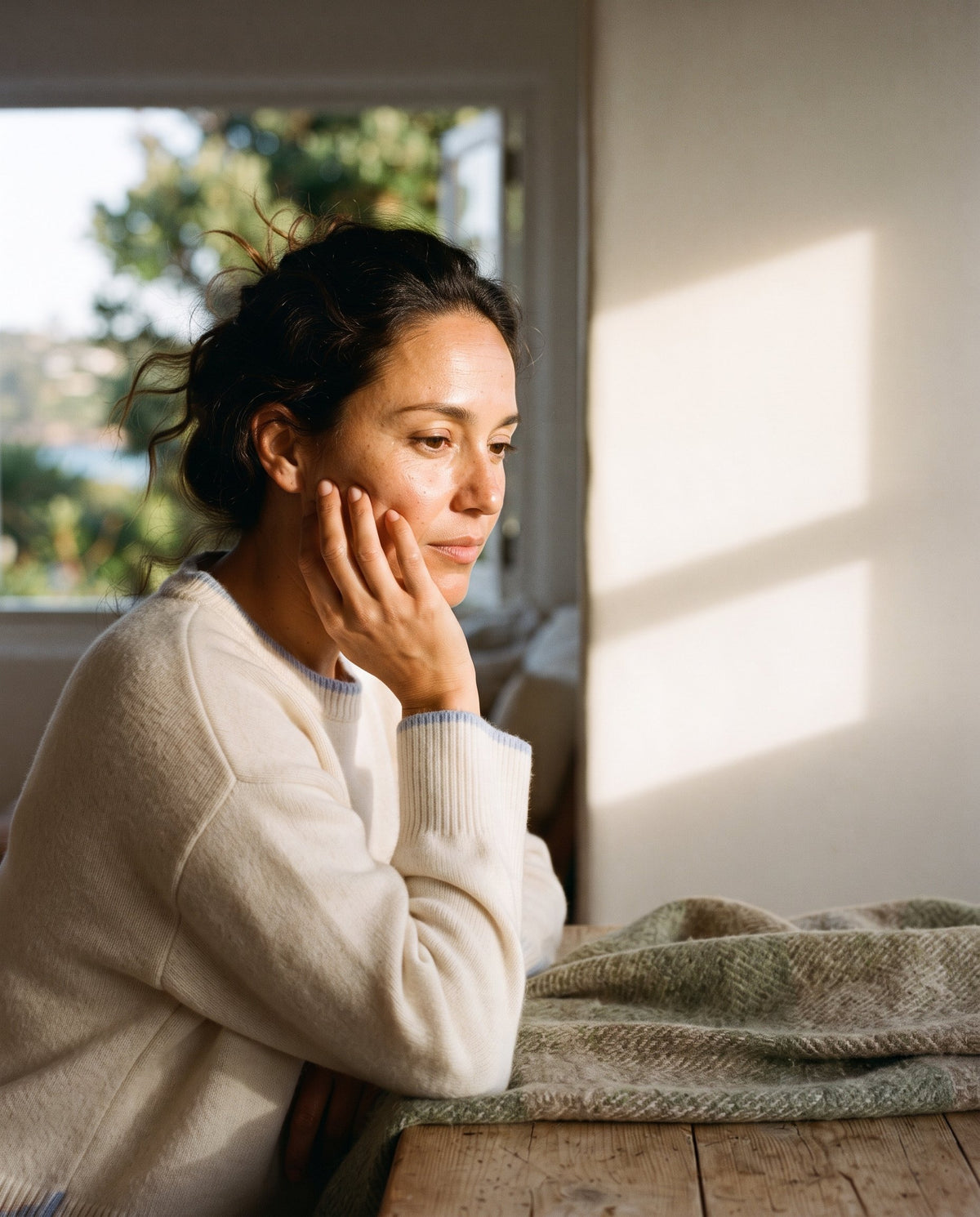 Woman touching her cheek, illustrating the everyday feeling of skin texture and comfort.