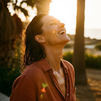 Woman in glowing golden high summer light, refreshed, glowing and happy