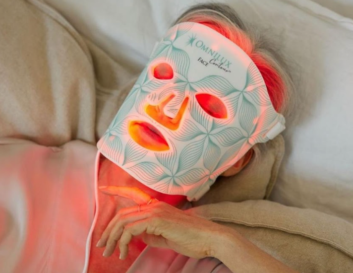 woman lying down wearing LED Light Therapy mask.
